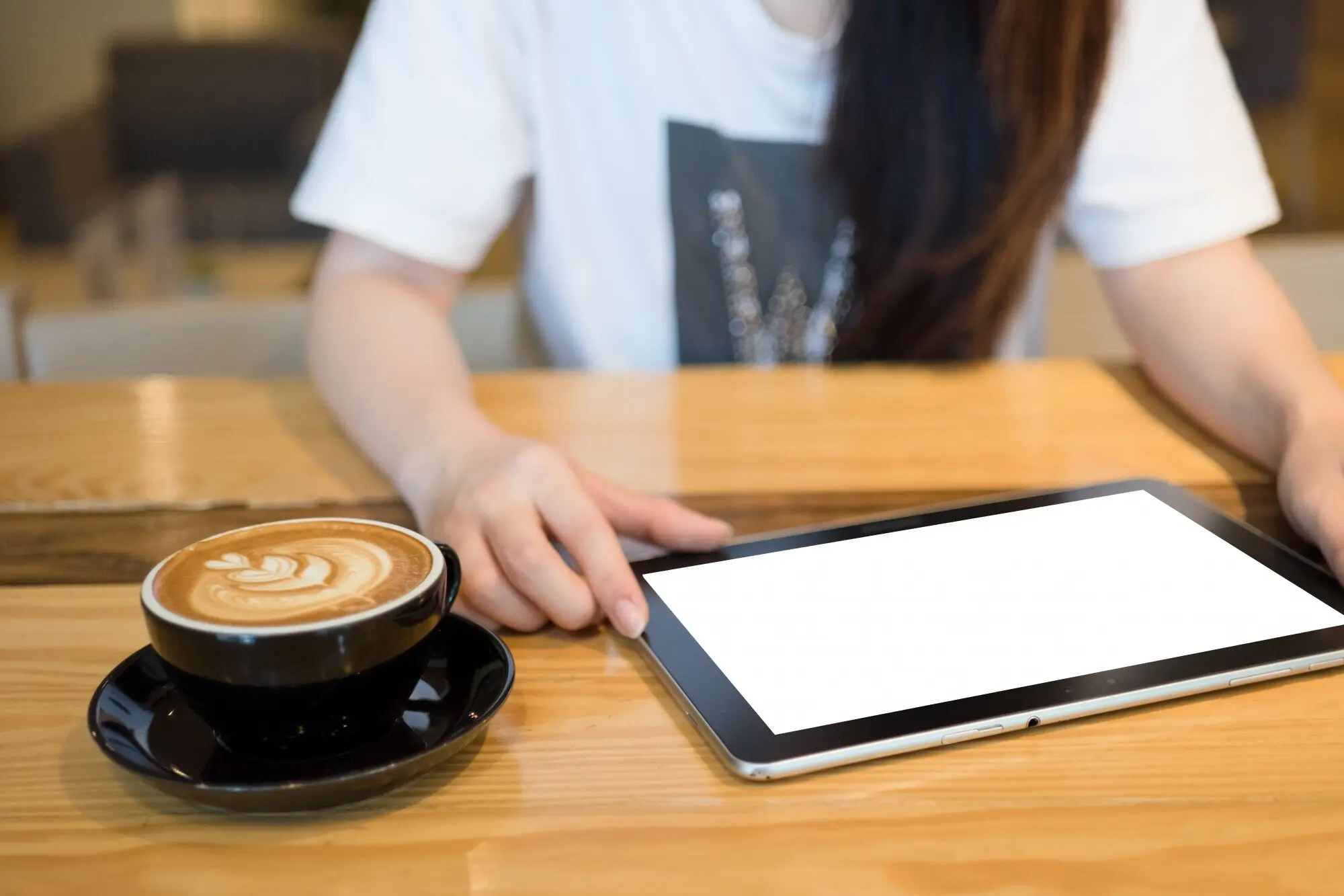 Eine Frau benutzt in einem Café ein Tablet.