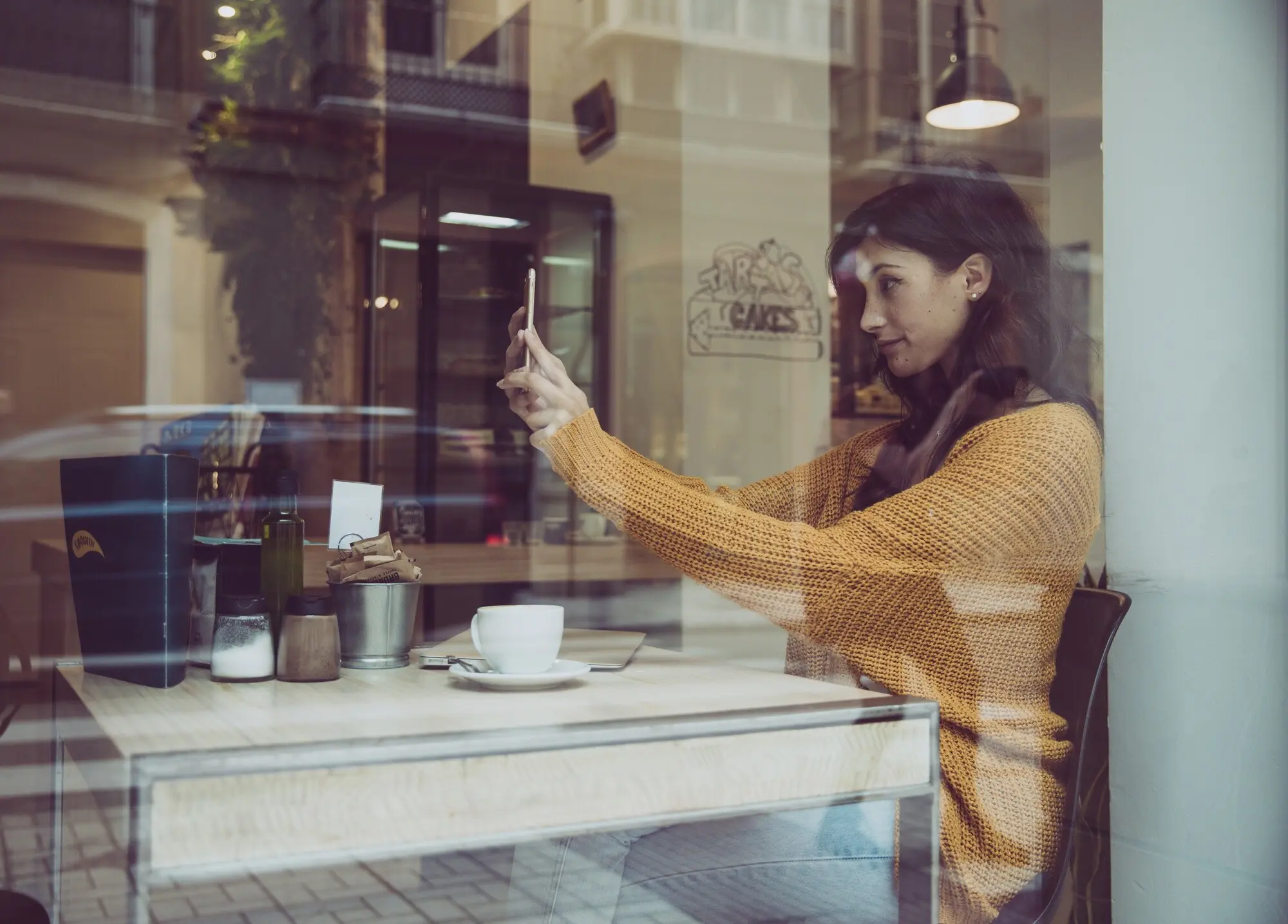 Eine Frau, die im Café ein Selfie macht.